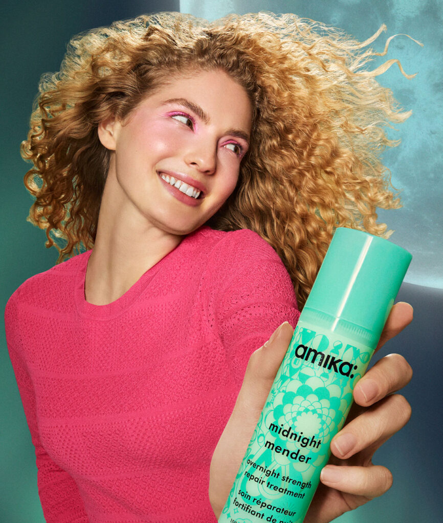 אישה מחזיקה את מסכת לילה לשיקום שיער midnight mender