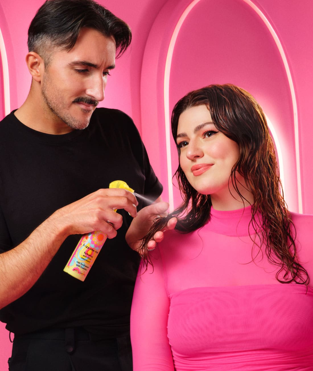 מעצב שיער משתמש בטיפול frizz-me-not לתוצאה של פן חלק ללא פריז